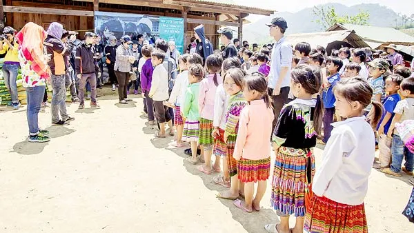 Cả nhóm đang trao tặng quà cho các em học sinh tỉnh Đắk Nông