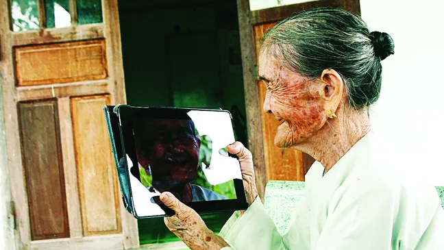 Bà mẹ Việt Nam anh hùng Võ Thị Tới nhìn chân dung mình trong iPad