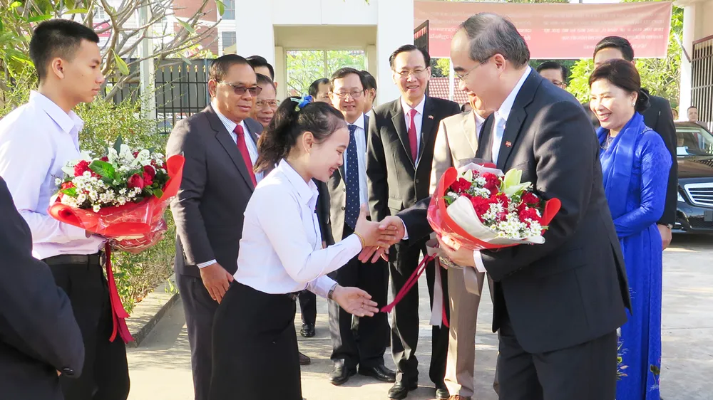 Học sinh Trường PTTH Hữu nghị Viêng Chăn - TPHCM tặng hoa, chào đón đoàn. Ảnh: KIỀU PHONG