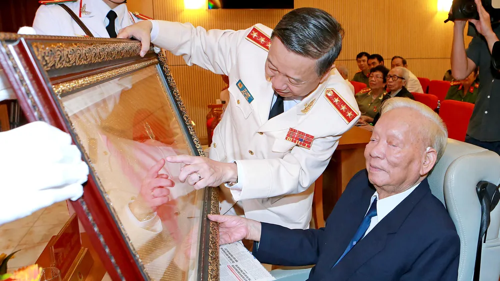 Thượng tướng  Tô Lâm, Ủy viên Bộ Chính trị,  Bí thư Đảng ủy Công an Trung ương, Bộ trưởng Bộ Công an trao tặng Cuốn thư ghi nhận công lao, đóng góp cho nguyên Ủy viên Bộ Chính trị, nguyên Chủ tịch nước Lê Đức Anh trong cuộc Gặp mặt truyền thống các thế hệ