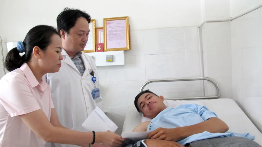 Đại diện Báo SGGP thăm và trao tiền bạn đọc hỗ trợ anh Đinh Phú Quý.  Ảnh: VIỆT NGA