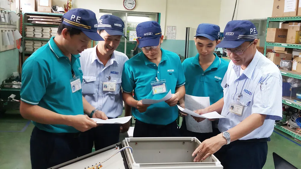 Anh Trịnh Minh Đức (bìa phải) cùng các đồng nghiệp thảo luận và thiết kế, chế tạo thành công máy kiểm tra dây điện 