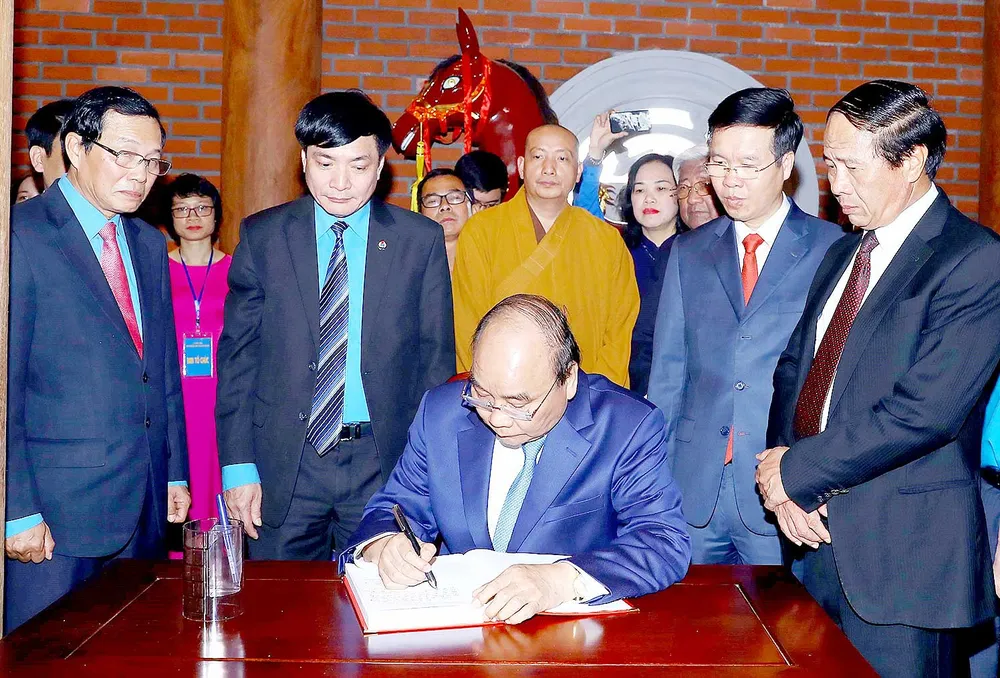 Thủ tướng Nguyễn Xuân Phúc ghi sổ lưu niệm tại Nhà tưởng niệm đồng chí Nguyễn Đức Cảnh.  Ảnh: TTXVN