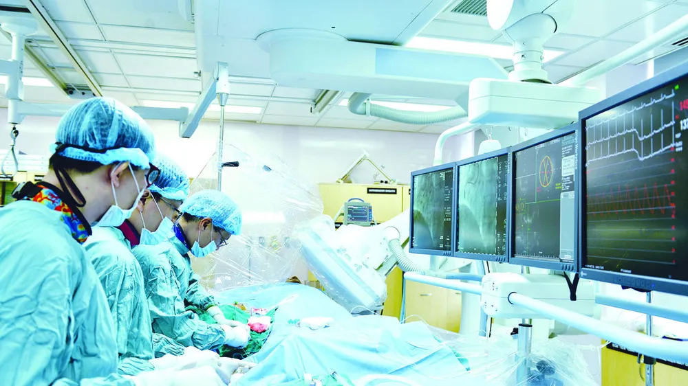 Bác sĩ Bệnh viện Đại học Y Dược TPHCM hướng dẫn bác sĩ  Bệnh viện Đa khoa Sóc Trăng phương pháp can thiệp tim mạch.   Ảnh: THÀNH AN