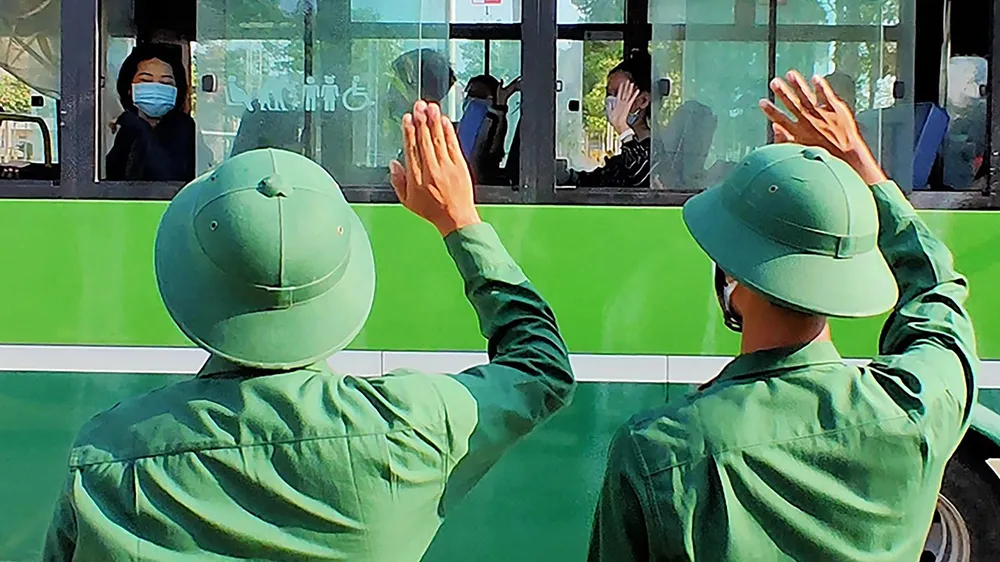 Các chiến sĩ Sư đoàn 317 chia tay công dân hoàn thành 14 ngày cách ly y tế lên xe về với gia đình. Ảnh: HOÀNG HÙNG