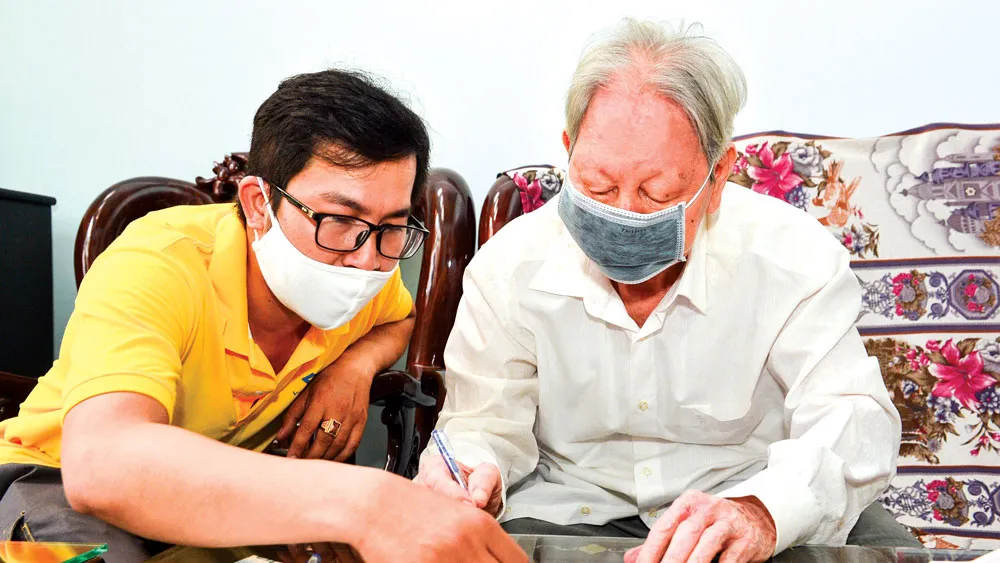 Bưu tá đến tận nhà  chi trả chế độ ưu đãi  người có công  với cách mạng tại quận 1, TPHCM. Ảnh: VIỆT DŨNG