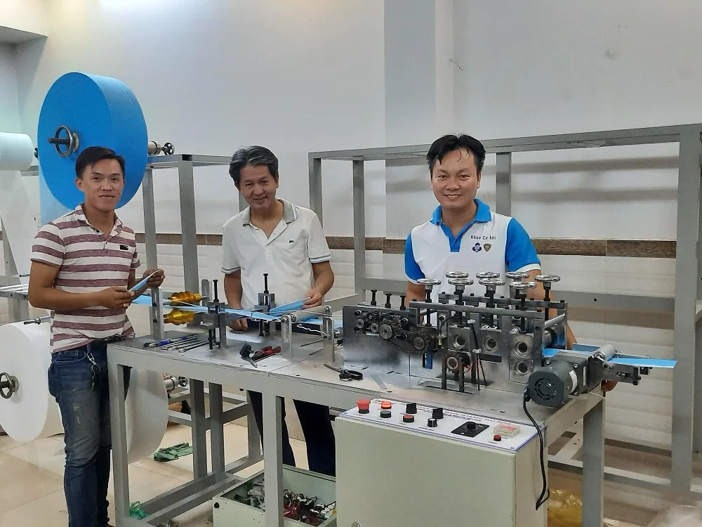 PGS.TS Nguyễn Hữu Lộc (giữa) và TS Nguyễn Thanh Hải (phải) bên máy tạo thân khẩu trang y tế.