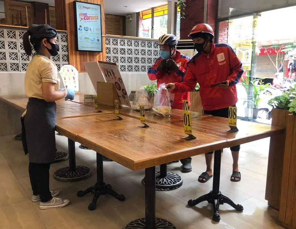 Một quán ăn trên địa bàn quận 8 kê bàn khoảng cách 2m giữa khách và nhân viên  nhằm phục vụ cho những món mang về. Ảnh: HOÀNG HÙNG