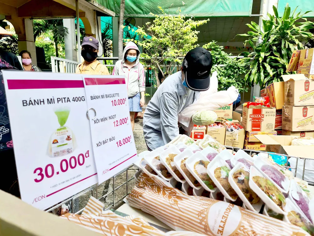 Chọn mua nhu yếu phẩm tại điểm bán dã chiến do Công ty TNHH Aeon Việt Nam tổ chức.  Ảnh: NGỌC HIỂN
