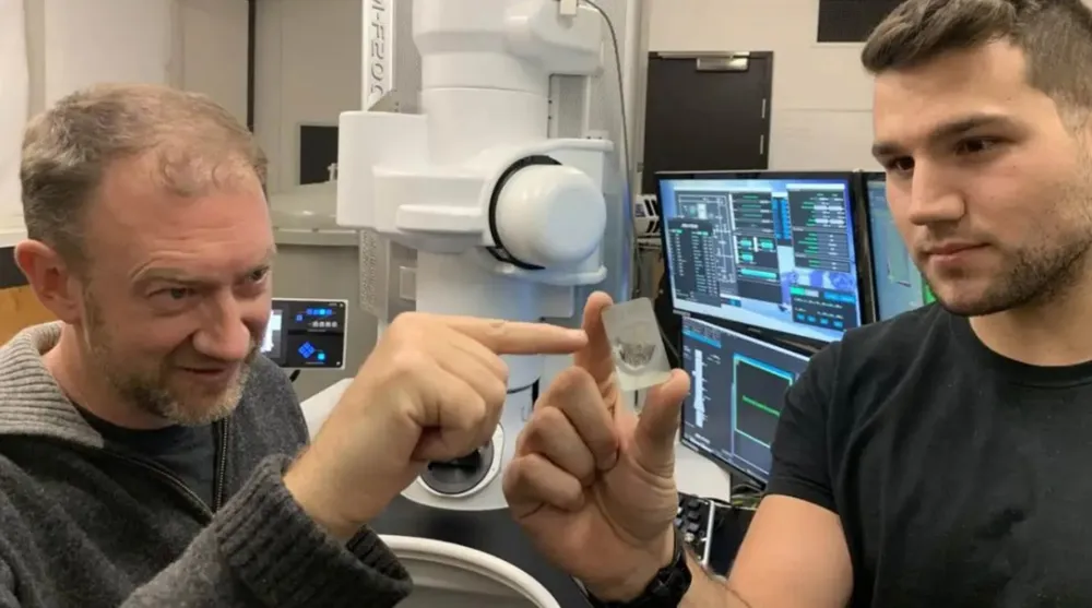 Các nhà khoa học cầm trên tay  một mẫu thiên thạch ureilite