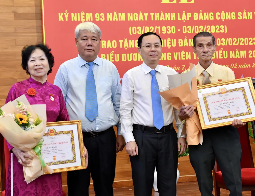 Phó Bí thư Thành ủy TPHCM Nguyễn Văn Hiếu và Bí thư Quận 7 Võ Khắc Thái trao Huy hiệu Đảng cho các đồng chí cao tuổi Đảng. Ảnh: VIỆT DŨNG