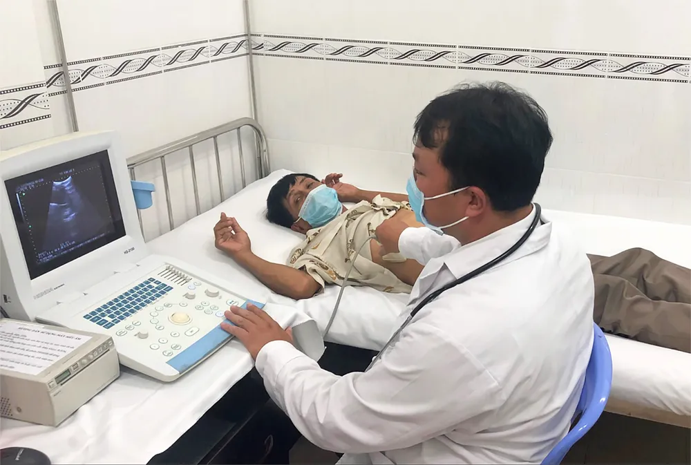 Bác sĩ tại TYT xã Vĩnh Lộc A, huyện Bình Chánh, TPHCM đang thăm khám và siêu âm chẩn đoán bệnh cho người dân