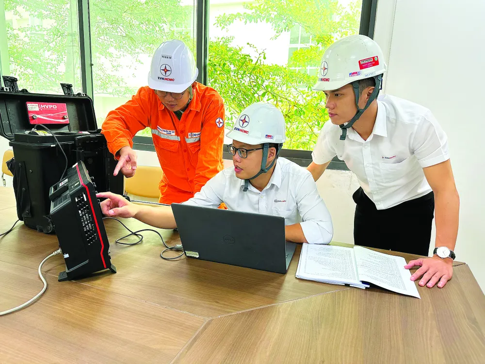 Hồ Bảo Huy (giữa) hướng dẫn các kỹ sư nắm bắt công nghệ chẩn đoán online cáp ngầm. Ảnh: THU HƯỜNG