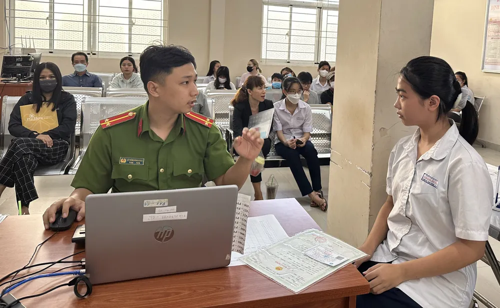 Các em học sinh được cán bộ công an hướng dẫn làm CCCD gắn chip. Ảnh: CHÍ THẠCH Các em học sinh được cán bộ công an hướng dẫn làm CCCD gắn chip. Ảnh: CHÍ THẠCH