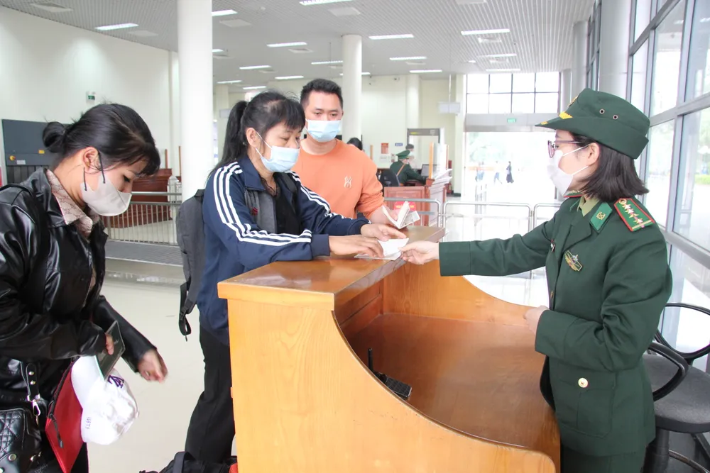 Cán bộ biên phòng tại Cửa khẩu Quốc tế Móng Cái làm thủ tục nhập cảnh cho khách du lịch Trung Quốc