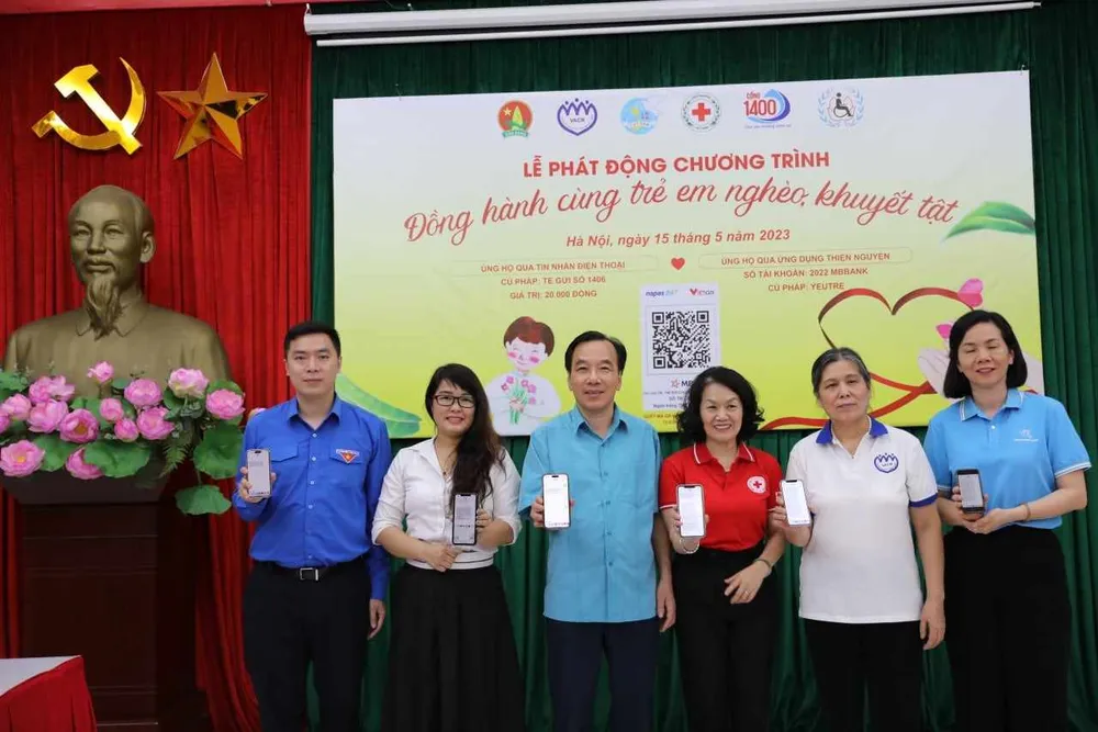 Đại diện các cơ quan chức năng thực hiện nhắn tin ủng hộ quỹ đồng hành cùng trẻ em nghèo, khuyết tật