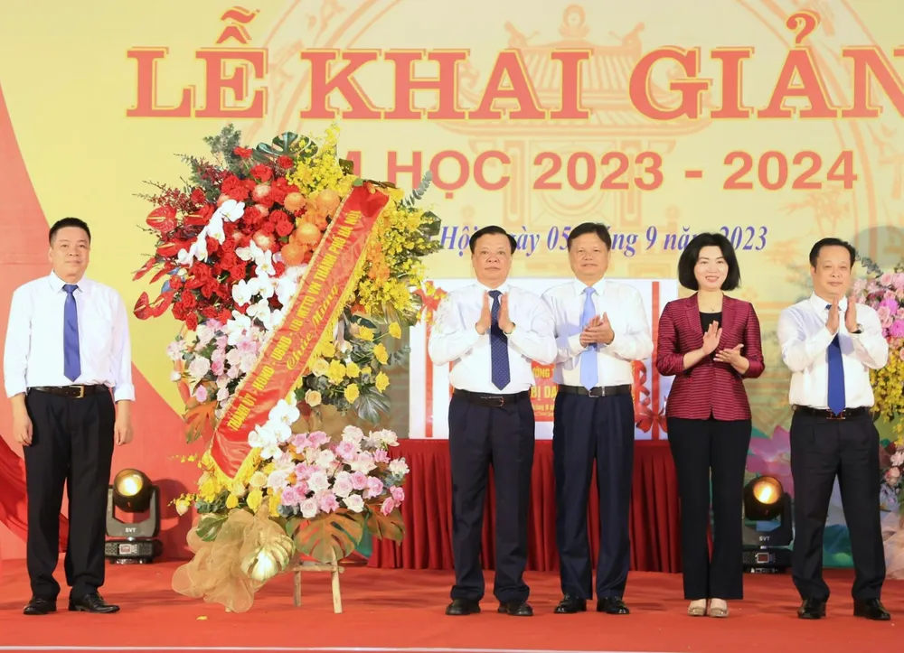 Bí thư Thành ủy Hà Nội Đinh Tiến Dũng tặng hoa chúc mừng thầy và trò Trường THCS Ngô Quyền. Ảnh: VIẾT CHUNG Bí thư Thành ủy Hà Nội Đinh Tiến Dũng tặng hoa chúc mừng thầy và trò Trường THCS Ngô Quyền. Ảnh: VIẾT CHUNG