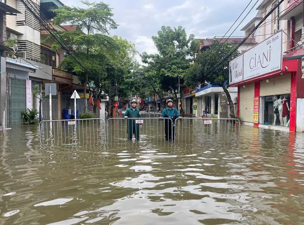 Lực lượng chức năng phường Sơn Tây triển khai các biện pháp đảm bảo an toàn cho nhân dân vùng bị ngập lụt. Ảnh: XỨ ĐOÀI