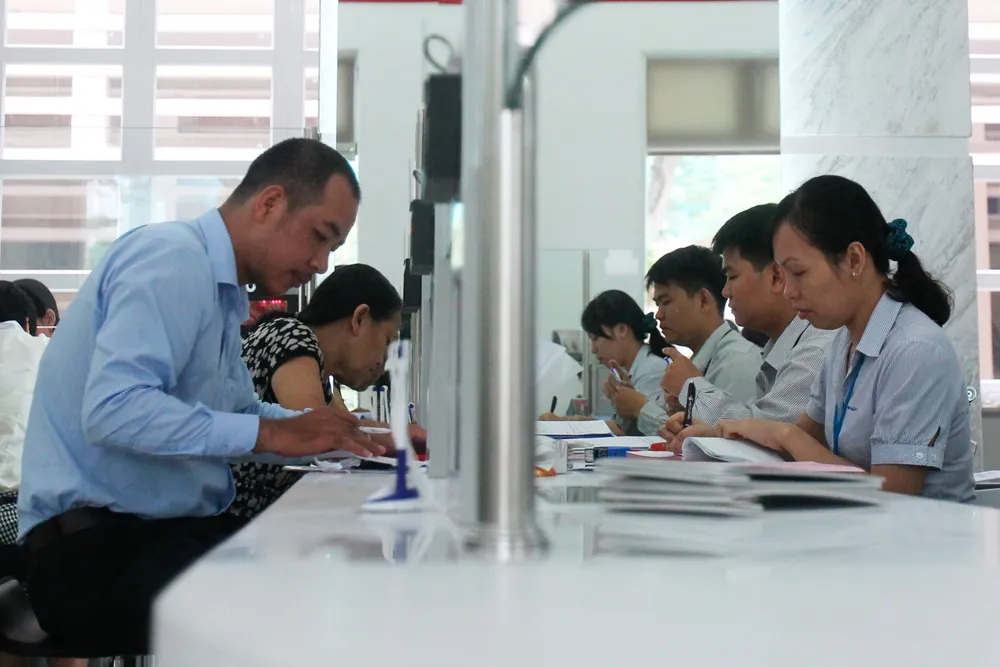 Cán bộ UBND quận 1 (TPHCM, bìa phải) giải quyết hồ sơ cho người dân