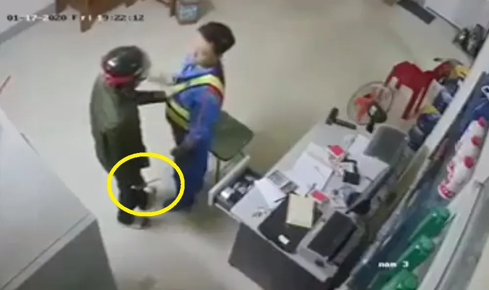 Đối tượng cầm dao khống chế nhân viên cửa hàng xăng dầu. Ảnh cắt từ clip