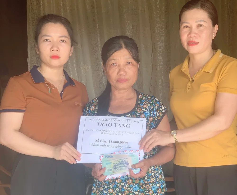 Trao 11 triệu đồng của bạn đọc Báo SGGP cho bà Dương Thị Lý, mẹ của em Trần Khánh Lộc. Ảnh: DƯƠNG QUANG