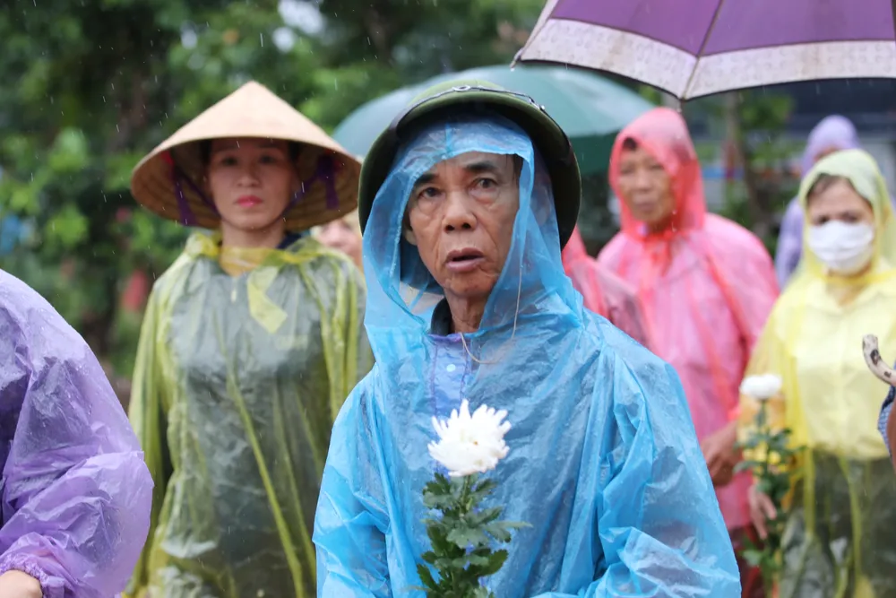 Người dân cầm bông hoa cúc trắng thương tiếc liệt sĩ Lê Ánh Sáng