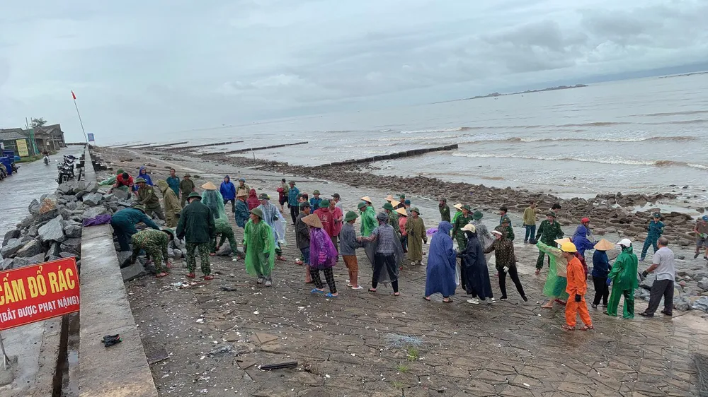 Người dân và lực lượng chức năng cùng đội mưa vận chuyển đá