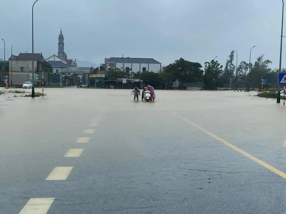 Công an huyện Lộc Hà lập hỗ trợ dắt phương tiện cho người dân qua khu vực đường ngập