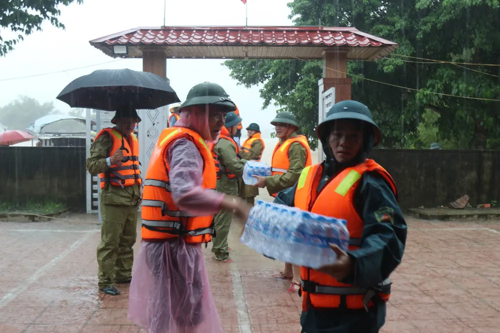 Lãnh đạo huyện Nghi Xuân (tỉnh Hà Tĩnh) vận chuyển mỳ tôm và nước uống đến hỗ trợ người dân ở ốc đảo thôn Hồng Lam, xã Xuân Giang.jpg