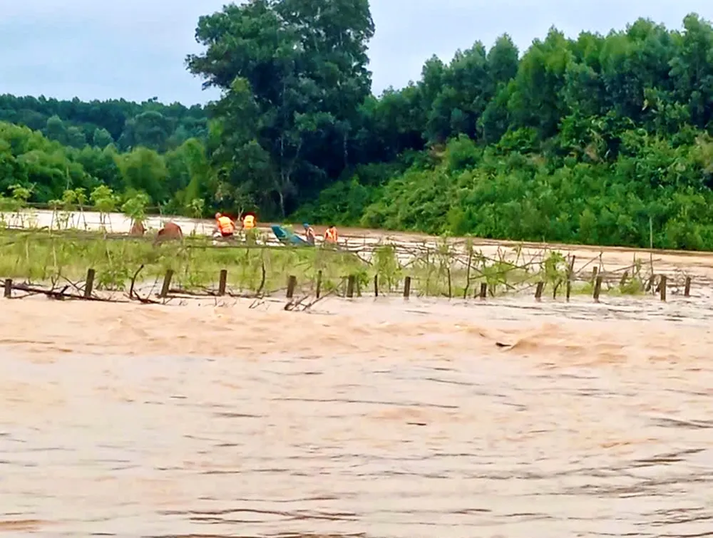 Lực lượng chức năng xã Lộc Yên dùng xuồng máy vượt dòng nước lũ để cứu người dân 