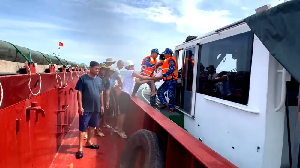 Cán bộ, chiến sĩ Hải đội 102 tiếp nhận cha con anh Nguyễn T.T., từ tàu hàng VINASHIN 555 để đưa vào bờ 