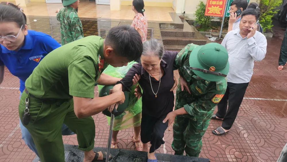 Lực lượng chức năng hỗ trợ sơ tán người dân ở xã Thiên Cầm, tỉnh Hà Tĩnh đến nơi trú tránh an toàn