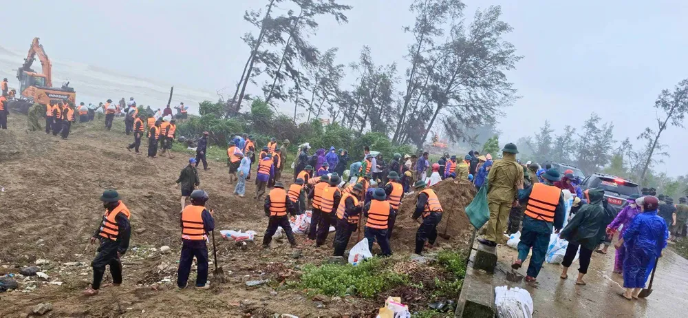 Lực lượng chức năng và người dân vận chuyển vật liệu gia cố bờ biển xã Đan Hải, tỉnh Hà Tĩnh