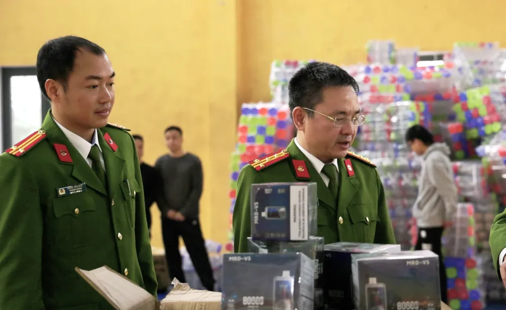 Đại tá Phạm Thanh Phương kiểm tra số thuốc lá điện tử tịch thu trong đường dây.jpg