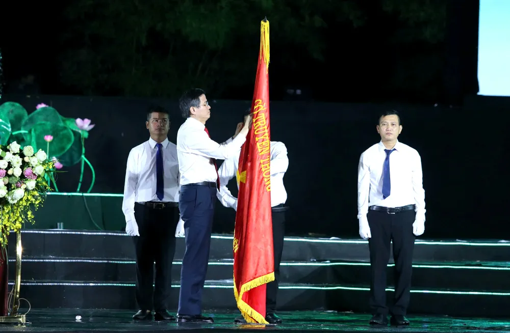 Đồng chí Đoàn Minh Huấn gắn Huân chương Lao động hạng Nhất lên cờ truyền thống của Khu Di tích Kim Liên
