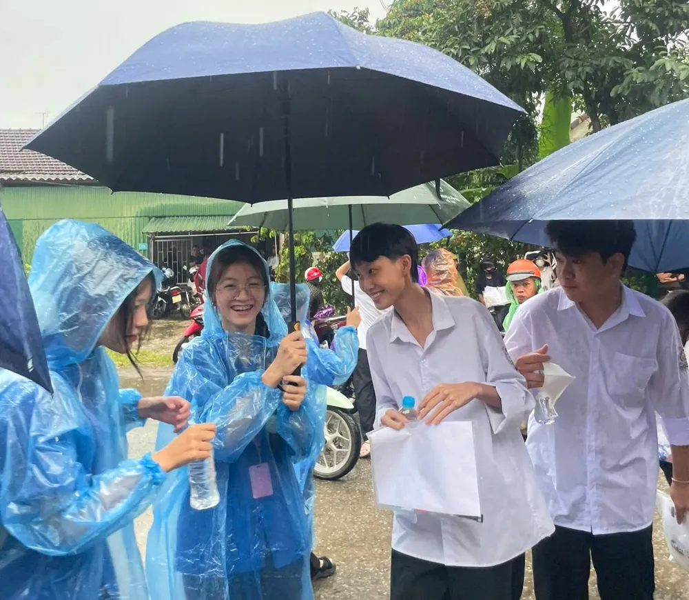 Đoàn viên, thanh niên dùng ô dù che mưa đưa đón thí sinh vào điểm thi 