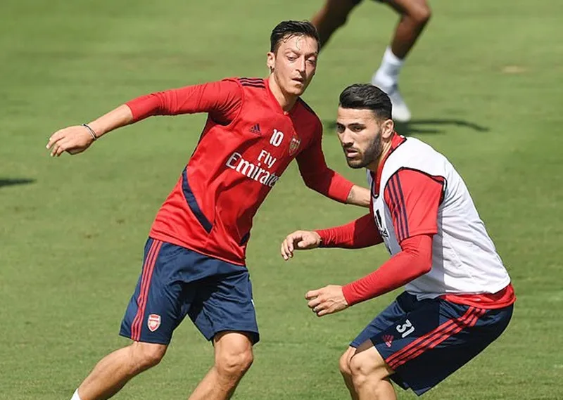 Mesut Oezil (trái) và Sead Kolasinac gặp rắc rối khi vừa trở về sau chuyến tập huấn tại Mỹ. Ảnh: Daily Mail