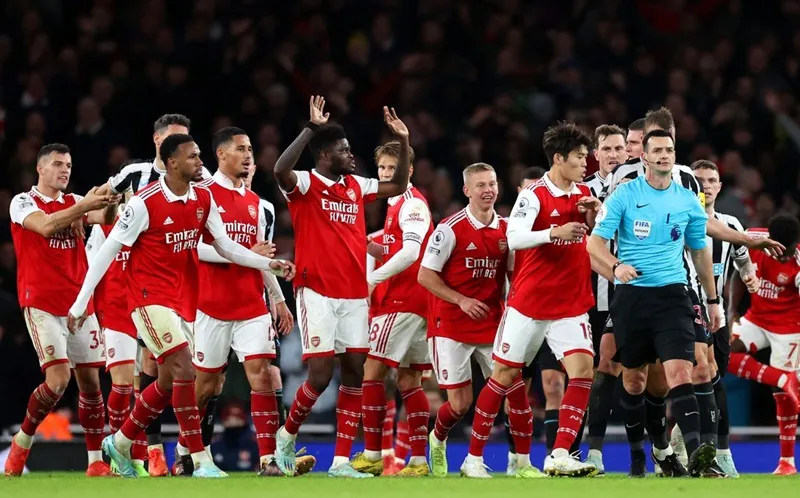 Cầu thủ Arsenal vây vào phản ứng đòi trọng tài trao cho quả phạt đền. Cầu thủ Arsenal vây vào phản ứng đòi trọng tài trao cho quả phạt đền.