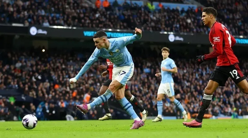Chú thích: Phil Foden (trái, Manchester City) ghi bàn vào lưới Manchester United