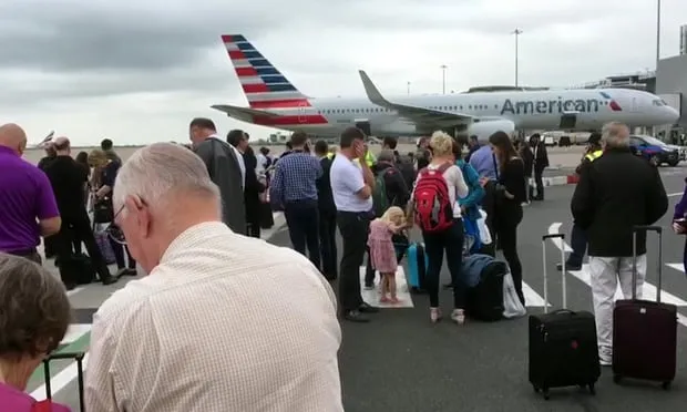 Hành khách tập trung trên đường băng sau khi được sơ tán khỏi máy bay ở sân bay Manchester, Anh, ngày 5-7-2017. Ảnh: AP