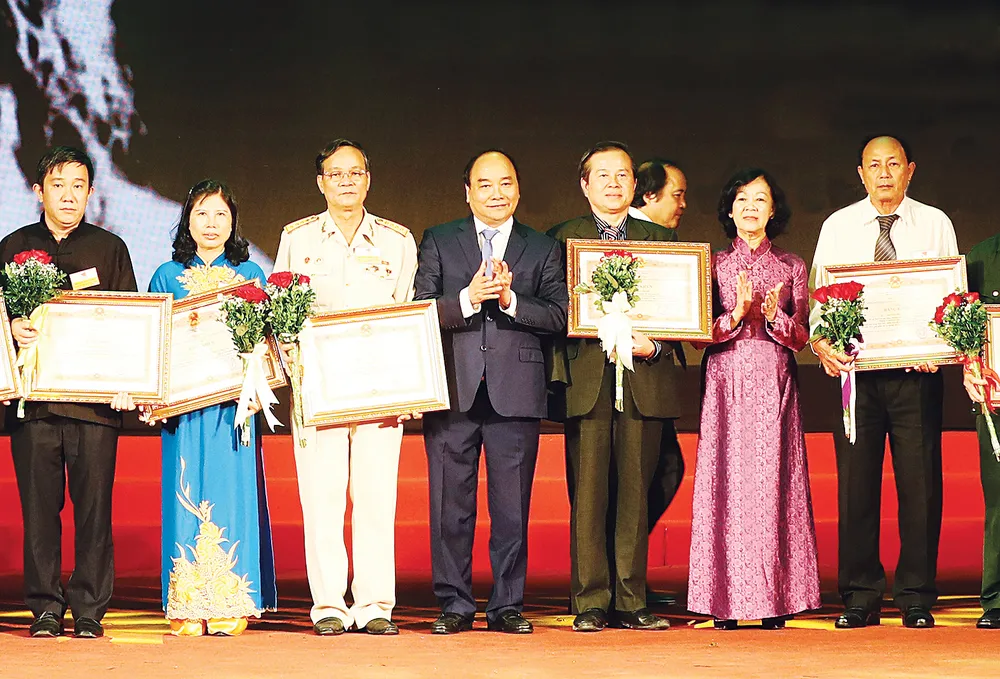 Thủ tướng Nguyễn Xuân Phúc trao bằng khen của Thủ tướng Chính phủ tặng các đại biểu  dự Hội nghị biểu dương người có công với cách mạng tiêu biểu toàn quốc