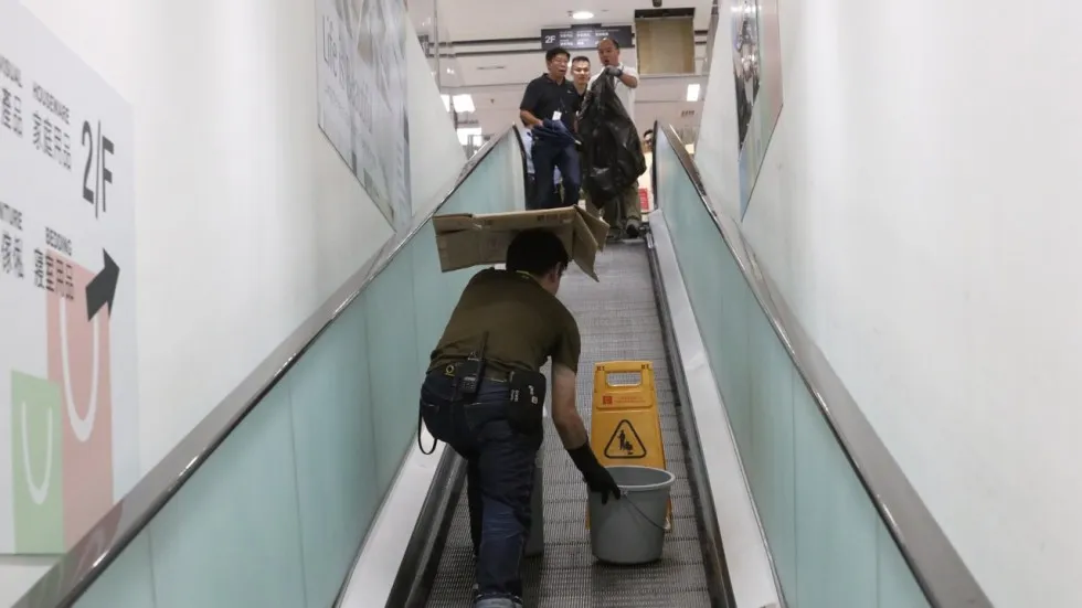 Nhân viên đặt thùng hứng axit nhỏ xuống từ trần trung tâm mua sắm Skyline Plaza tại quận Tsuen Wan ở Hồng Công (Trung Quốc) ngày 6-8-2017. Ảnh: SCMP