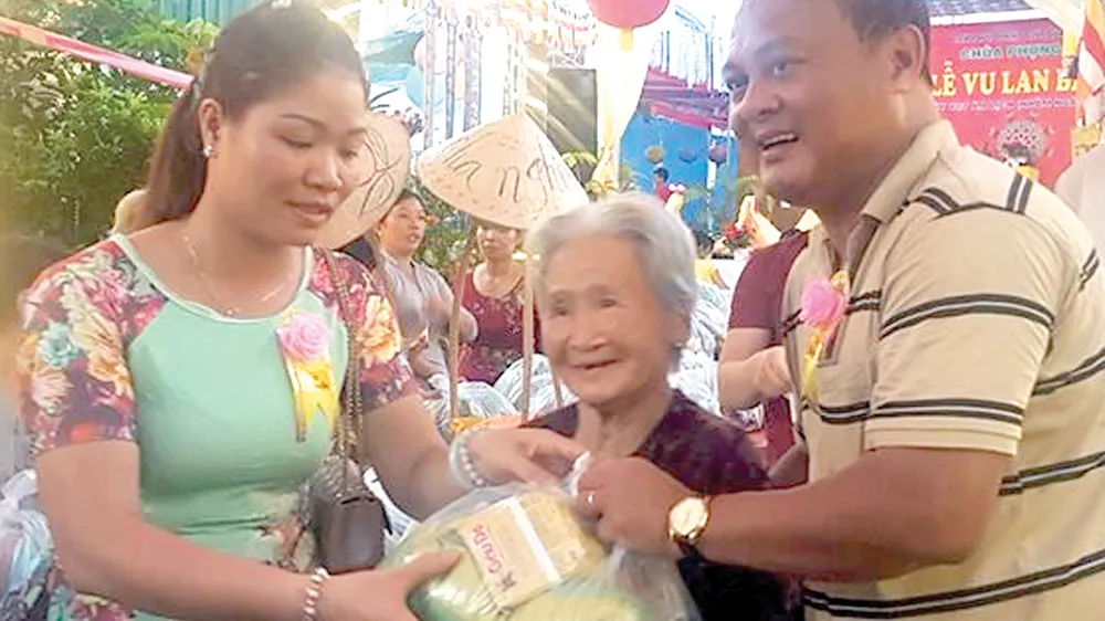  Vợ chồng anh Tú phát quà tặng người nghèo trong lễ Vu Lan tại chùa Phụng Ân                                           Ảnh: HOÀI NAM