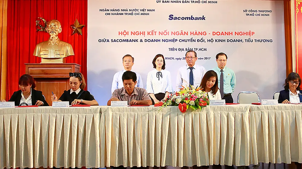 Ký kết cung ứng vốn giữa ngân hàng và các hộ kinh doanh, tiểu thương          Ảnh: HUY ANH