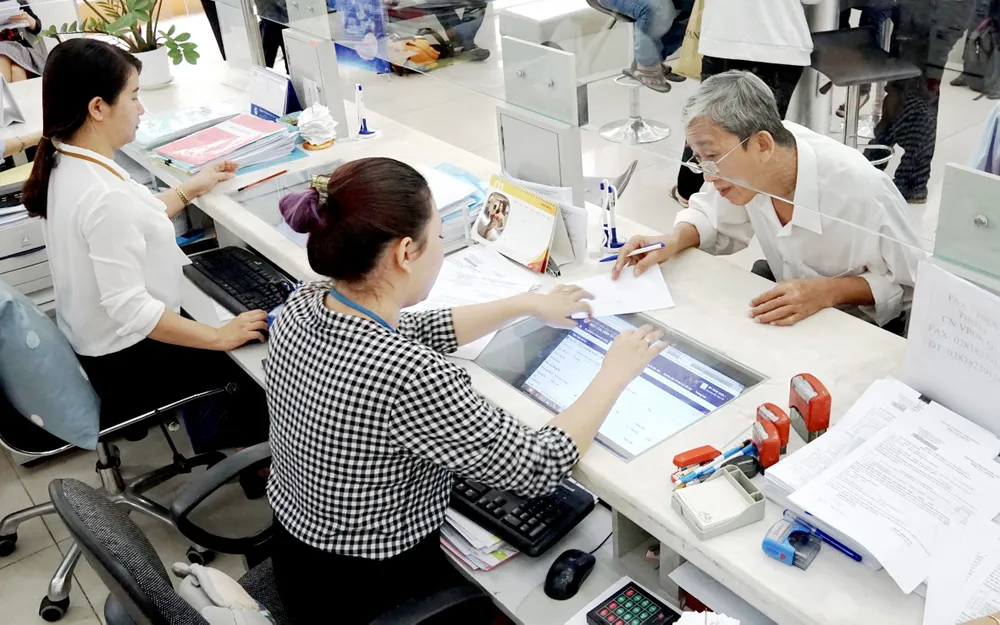 Quận 1 (TPHCM) được chọn thí điểm đô thị thông minh.  Trong ảnh: Cán bộ UBND quận 1 tiếp nhận hồ sơ và nhập liệu thông tin  trên máy tính để người dân theo dõi tiến trình giải quyết.           Ảnh: HOÀNG HÙNG