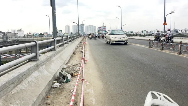 Phần lề đường dành cho người đi bộ trên cầu Nguyễn Tri Phương đang bị  phá bỏ để mở rộng lòng đường, người đi bộ không còn lối đi qua cầu   