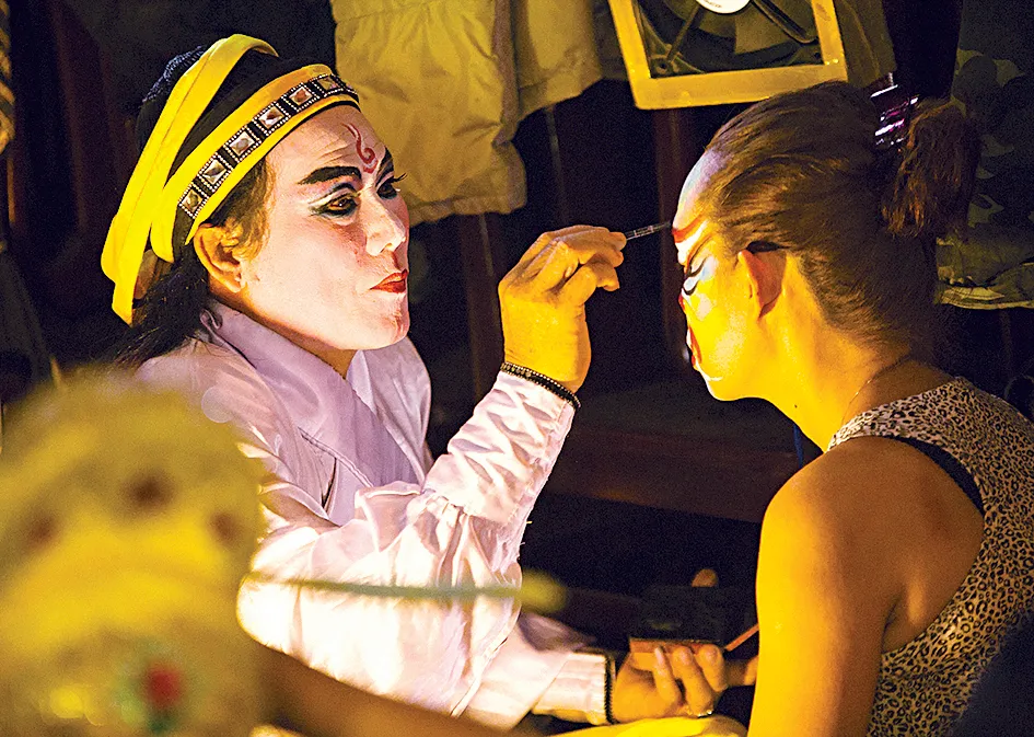 Các nghệ sĩ vẽ mặt, hóa trang trước khi buổi diễn bắt đầu. Tùy theo vai diễn, khuôn mặt có khi phải mất hơn 1 giờ để vẽ              Ảnh: Dương Rkudo