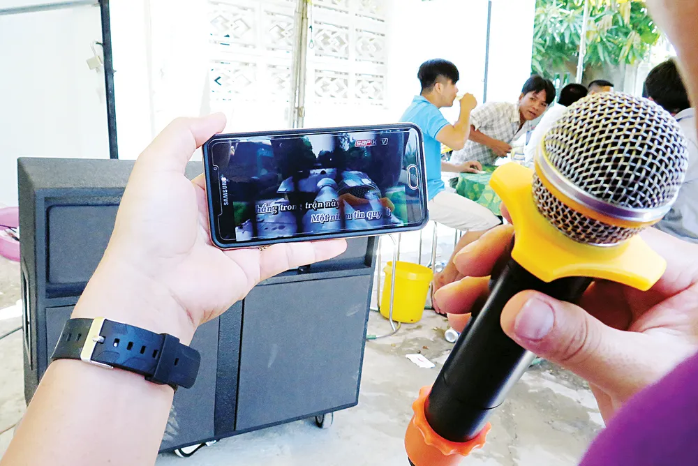 Một đám tiệc, chỉ cần dàn loa, micro kết nối phần mềm karaoke trên điện thoại di động, là đủ hành hạ làng xóm                     .  Ảnh: DŨNG PHƯƠNG