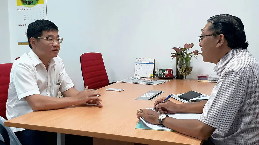 Ông Lưu Hải Ca (trái) trả lời phóng viên Báo SGGP  về việc giải quyết đền bù cho cư dân bị thiệt hại trong vụ cháy.   Ảnh: THU HƯỜNG