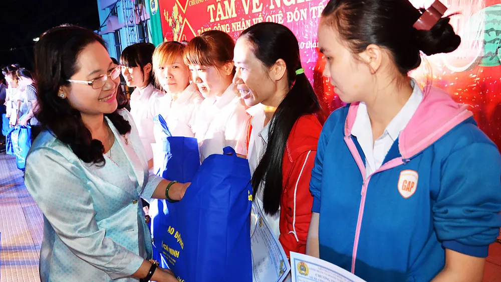 Lãnh đạo TPHCM trao tấm vé nghĩa tình (mỗi năm TPHCM tặng hơn 30.000 vé xe) tặng công nhân về quê đón tết    Ảnh: THÁI PHƯƠNG